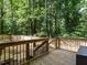 View of wood deck with black metal railings overlooking a fenced backyard with mature trees at 114 Oxpens Rd, Cary, NC 27513
