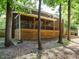 View of backyard with mature trees behind a large screened-in back porch on brick home at 114 Oxpens Rd, Cary, NC 27513