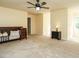Open, tan bedroom features a bed, nightstand, ceiling fan and multiple entryways at 114 Oxpens Rd, Cary, NC 27513