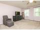 Bright bedroom featuring two windows, a green dresser, and a comfy chair with footstool at 114 Oxpens Rd, Cary, NC 27513