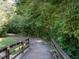 Scenic wooded walking path with a small wooden bridge and lush green surroundings at 114 Oxpens Rd, Cary, NC 27513