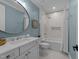 Charming bathroom featuring a double vanity, a large mirror, and a bathtub with shower at 1208 Hunting Ridge Rd, Raleigh, NC 27615