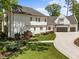 Beautifully landscaped front yard of an elegant white home with a three-car garage at 1208 Hunting Ridge Rd, Raleigh, NC 27615