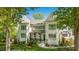Elegant two-story home with white facade, multiple windows, and a covered porch area with meticulous landscaping at 1208 Hunting Ridge Rd, Raleigh, NC 27615