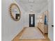 Bright foyer with hardwood floors, decorative mirror, stylish console table and lighting, creating a welcoming entrance at 1208 Hunting Ridge Rd, Raleigh, NC 27615