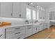 Bright kitchen with white cabinetry, a farmhouse sink, and a view from the window at 1208 Hunting Ridge Rd, Raleigh, NC 27615