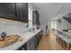 Modern kitchenette with black cabinets, marble countertops, stainless steel appliances, and hardwood floors at 1208 Hunting Ridge Rd, Raleigh, NC 27615