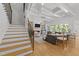 Open-concept living room with wood floors, stylish furniture, fireplace, and seamless transition to the outdoors at 1208 Hunting Ridge Rd, Raleigh, NC 27615