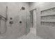 Modern shower featuring stylish tile, glass door, and convenient storage niches at 1208 Hunting Ridge Rd, Raleigh, NC 27615