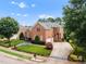 Aerial view of brick home showcasing mature landscaping and driveway at 12140 Pawleys Mill Cir, Raleigh, NC 27614