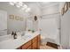 Well-lit bathroom featuring a large vanity and bathtub with shower at 12140 Pawleys Mill Cir, Raleigh, NC 27614