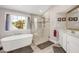 Bright bathroom with a soaking tub, glass shower, and white vanity with gold framed mirror at 12140 Pawleys Mill Cir, Raleigh, NC 27614