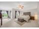 Spacious bedroom with large windows, a tufted headboard, and a cozy seating area with ottoman at 12140 Pawleys Mill Cir, Raleigh, NC 27614