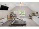 Large carpeted bonus room with a treadmill and office setup with backyard views at 12140 Pawleys Mill Cir, Raleigh, NC 27614