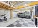 Spacious garage featuring overhead storage, epoxy flooring, and a modern vehicle at 12140 Pawleys Mill Cir, Raleigh, NC 27614