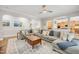 Open living room featuring hardwood floors, an extra-large sectional, and a view to the kitchen at 12140 Pawleys Mill Cir, Raleigh, NC 27614