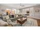 Expansive living room features hardwood floors, an extra-large sectional, and large windows to the backyard at 12140 Pawleys Mill Cir, Raleigh, NC 27614