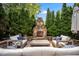 Inviting outdoor seating area with stone fireplace and professionally landscaped yard at 12140 Pawleys Mill Cir, Raleigh, NC 27614