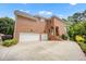 Rear view of a brick home featuring an attached garage and staircase to the entrance at 12140 Pawleys Mill Cir, Raleigh, NC 27614