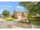 Side view of brick home showcasing manicured lawn, mature trees, and attached garages at 12140 Pawleys Mill Cir, Raleigh, NC 27614