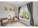 Sitting area by a window with gray chairs, a small table, sunflower artwork, and natural light at 12140 Pawleys Mill Cir, Raleigh, NC 27614