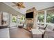 Relaxing sunroom featuring a stone fireplace, ceiling fan and outdoor views at 12140 Pawleys Mill Cir, Raleigh, NC 27614