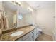 Well-lit bathroom featuring granite counters, dual sinks, and tub with shower at 124 Roscommon Ln, Clayton, NC 27520