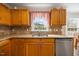 Kitchen close up featuring wood cabinets, granite countertops, and stainless steel dishwasher at 124 Roscommon Ln, Clayton, NC 27520