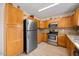 Kitchen with wooden cabinets, stainless steel appliances, and light, modern floors at 124 Roscommon Ln, Clayton, NC 27520