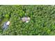 A lush, aerial view showcasing the home and pool surrounded by dense trees and landscaping at 131 Lavinia Ln, Chapel Hill, NC 27516