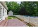 Charming backyard with a white picket fence, pool, patio, and verdant landscaping at 131 Lavinia Ln, Chapel Hill, NC 27516