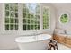 Bright bathroom features a soaking tub with large windows and custom storage at 131 Lavinia Ln, Chapel Hill, NC 27516
