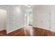 Bright bedroom featuring hardwood floors, designer wallpaper, and a view to an ensuite bathroom at 131 Lavinia Ln, Chapel Hill, NC 27516