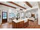 Gourmet kitchen with wooden beams, chandelier lighting, and an open view into the living space at 131 Lavinia Ln, Chapel Hill, NC 27516