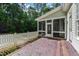 Covered patio with brick floor, white railings, and wooded views at 131 Lavinia Ln, Chapel Hill, NC 27516