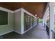 Long porch with dark stained wood ceiling, sconce lighting, and an iron railing at 131 Lavinia Ln, Chapel Hill, NC 27516