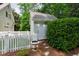 A detached shed adjacent to the main house, surrounded by lush landscaping and a white picket fence at 131 Lavinia Ln, Chapel Hill, NC 27516