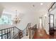 Elegant staircase with wrought iron railing, hardwood floors, and a decorative chandelier at 131 Lavinia Ln, Chapel Hill, NC 27516