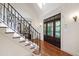 Elegant staircase showcasing detailed wrought iron railings and hardwood flooring with natural light at 131 Lavinia Ln, Chapel Hill, NC 27516