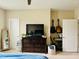 Bright bedroom includes a TV on a dresser, mirror, and guitars hung on the wall at 142 Philips Sq, Chapel Hill, NC 27516