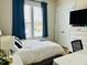 Bright bedroom features a large window, modern furnishings, and fresh white and blue decor at 142 Philips Sq, Chapel Hill, NC 27516