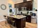 Modern kitchen with dark cabinets, stainless steel appliances, and a granite-topped island at 142 Philips Sq, Chapel Hill, NC 27516