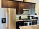 Well-equipped kitchen featuring stainless steel appliances, granite countertops, and dark wood cabinetry at 142 Philips Sq, Chapel Hill, NC 27516