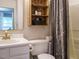 Functional bathroom with white fixtures, rustic wood accents, and practical storage solutions at 1509 Elkpark Dr, Raleigh, NC 27610