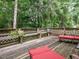 A spacious wood deck with built-in seating provides an inviting outdoor retreat surrounded by a lush, green forest at 1509 Elkpark Dr, Raleigh, NC 27610