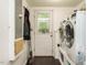 Functional laundry room with modern washer and dryer, access door, and storage at 1509 Elkpark Dr, Raleigh, NC 27610