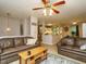 Open-concept living room with stylish hardwood floors, a ceiling fan, and comfortable seating adjacent to the dining area at 1509 Elkpark Dr, Raleigh, NC 27610