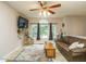 Cozy living room featuring a ceiling fan, comfortable leather seating, and large windows with ample natural light at 1509 Elkpark Dr, Raleigh, NC 27610