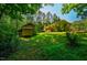 Green backyard features a small outdoor shed and is surrounded by mature trees at 1511 Hatch Rd, Chapel Hill, NC 27516