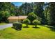 Beautifully landscaped front yard featuring manicured bushes, flowering trees, and a well-maintained lawn leading to the home at 1511 Hatch Rd, Chapel Hill, NC 27516